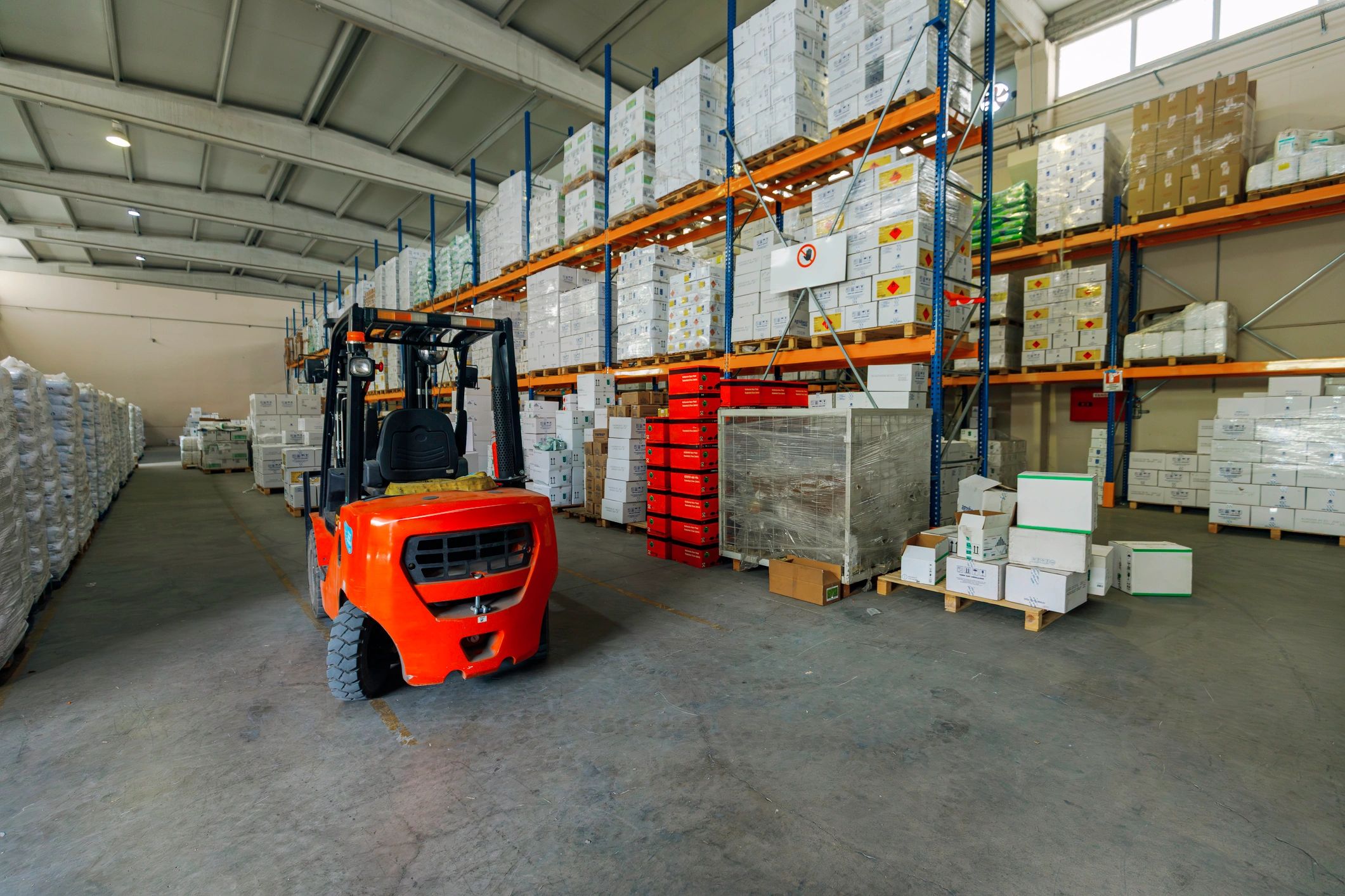 Forklift operating in a modern warehouse aisle